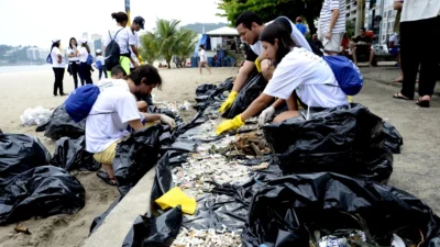 Grupos de voluntários separam resíduos coletados em mutirão de limpeza nas praias de Niterói, durante o Clean Up Day 2025.