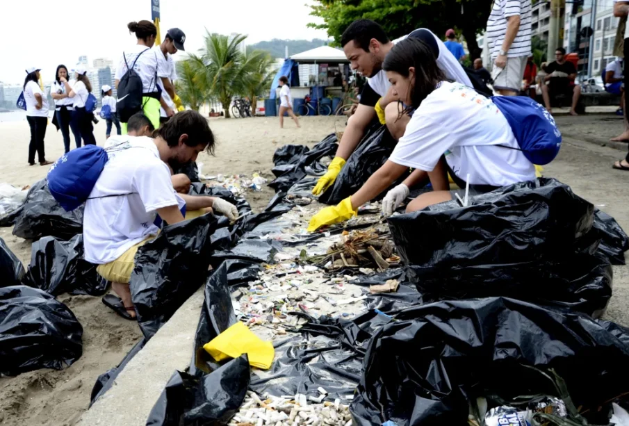 Grupos de voluntários separam resíduos coletados em mutirão de limpeza nas praias de Niterói, durante o Clean Up Day 2025.