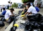 Grupos de voluntários separam resíduos coletados em mutirão de limpeza nas praias de Niterói, durante o Clean Up Day 2025.